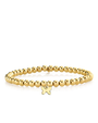Gold beaded bracelet with a butterfly charm on a white background