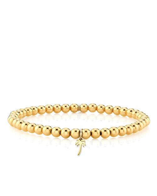 Gold beaded bracelet with a palm tree charm on a white background