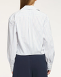 Person wearing a white shirt with blue vertical stripes and navy pants on a white background