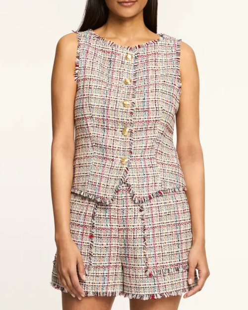 Woman wearing a plaid vest with buttons on a plain background