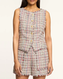 Woman wearing a plaid vest with buttons on a plain background