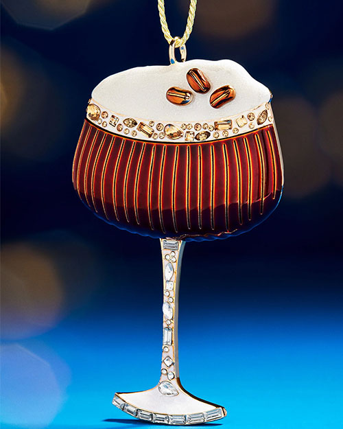 A glass of coffee featuring a gold chain hanging from its edge, adding an elegant touch to the beverage.