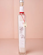 A clear bottle filled with sea salt, elegantly adorned with a red ribbon for a charming presentation.