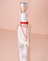A glass bottle of sea salts, embellished with a red ribbon, adding a festive flair to bathroom decor.