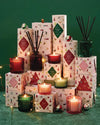 A collection of Christmas candles in boxes, adorned with various holiday decorations and festive elements.
