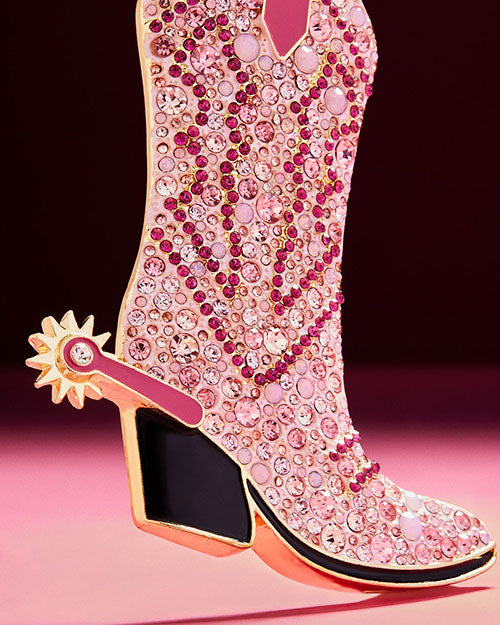  A decorative pink cowboy boot with gold spur ornament embellished with sparkling crystals, perfect for holiday tree decor.