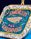 A decorative Christmas ornament featuring smoked sardines, perfect for a whimsical holiday tree theme.