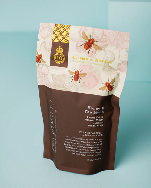 A bag of salt soak with a vibrant flower design, showcasing bees around it.