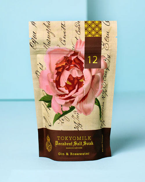 A bag of bath salts, featuring delicate pink petals and a soothing, aromatic blend for a relaxing bath experience.