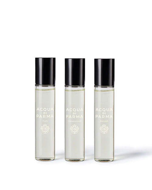 Three stylish perfume bottles on a white background, emphasizing their varied forms and vibrant hues.