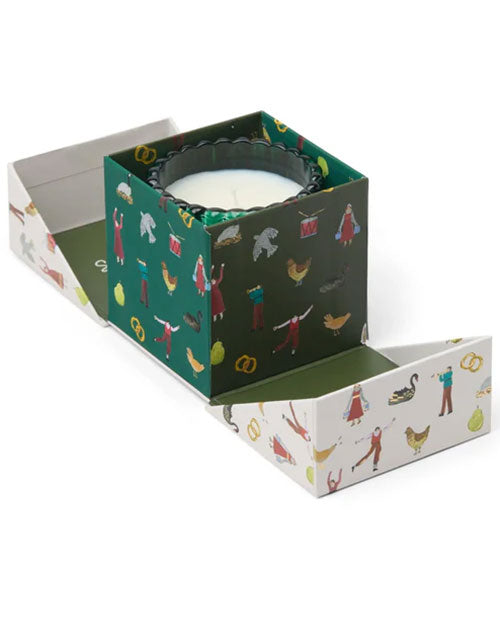 A decorative candle nestled in a green-covered gift box, ready for presentation or celebration.