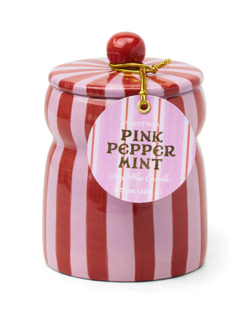 A pink peppermint candle with a decorative red and pink striped lid, perfect for creating a cozy atmosphere.