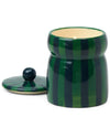 A Balsam Fir candle with a decorative blue and green striped lid.