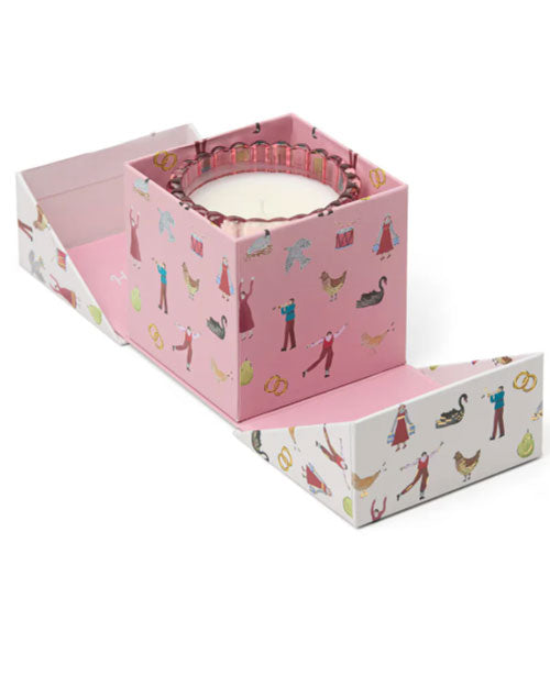  A Christmas themed box opened showcasing a single pink glass jar candle inside.