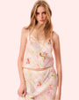 A model poses in a vibrant floral print dress, showcasing a blend of colors and patterns against a neutral background.