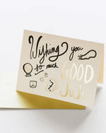 A vibrant card displaying the message "Wishing you so much good juju" in cheerful lettering, surrounded by decorative elements.