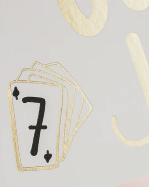 Detailed view of a gold foil card showcasing the number seven in an elegant font.