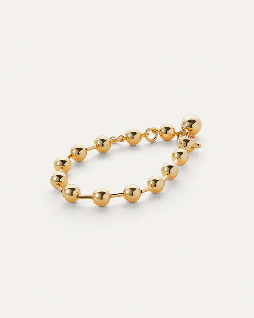  A gold bracelet with spherical balls, showcasing a minimalist and elegant design.