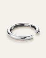 A sleek silver tubular bangle, highlighting its refined and modern design.