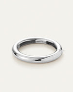 A sleek silver tubular bangle, highlighting its refined and modern design.