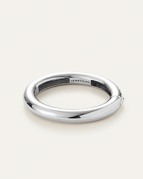 A sleek silver tubular bangle, highlighting its refined and modern design.