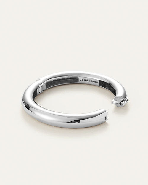 A sleek silver tubular bangle, highlighting its refined and modern design.