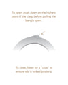 A bracelet displaying instructions to push down on the highest point of the clasp to open it.