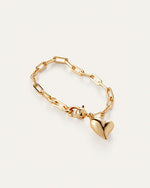 A gold heart bracelet featuring a delicate chain link design, elegantly showcasing its shimmering finish.