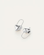 A pair of silver earrings shaped like hearts