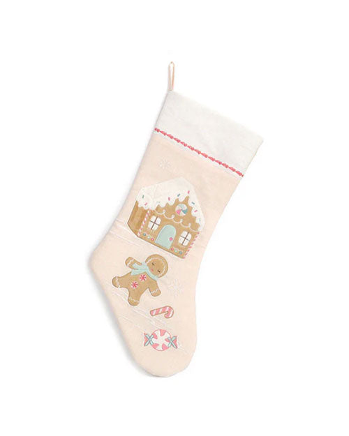 A light beige Christmas stocking with a white cuff and red trim, decorated with an embroidered gingerbread house, gingerbread man, and peppermint candies along the center. The background is plain white.