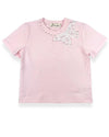  A little girl's pink t-shirt featuring a white lace trim and a butterfly motif with pearl studs.