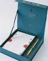 A blue box holds a pen and notepad, showcasing Good Juju Ink Enchanted Garden Lux Thank You Stationery design.