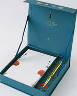 A blue box holds a pen and notepad, showcasing Good Juju Ink Enchanted Garden Lux Thank You Stationery design.