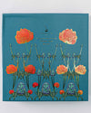 A blue-covered stationary box, "Good Juju Ink Enchanted Garden," embellished with floral designs.