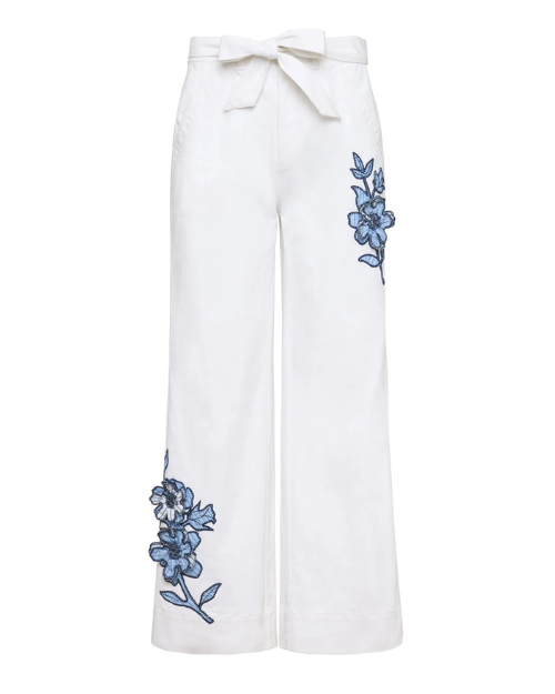 White pants with blue floral embroidery on a white background
