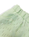 The Doe A Dear Yasmine shorts feature a refined green tweed fabric with intricate pearl and beaded accents, captured in an up-close image.
