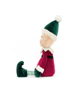 Side profile of a plush elf toy wearing a red outfit with white fur trim, green gloves and curled-toe shoes, a green and white striped hat with a white pom-pom, and green and white striped legs.