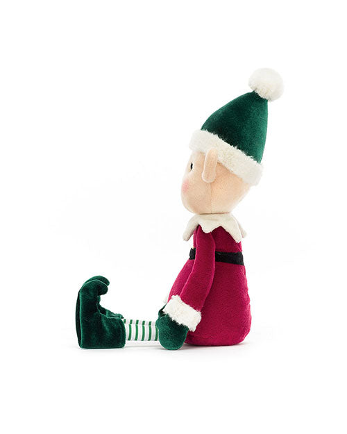 Side profile of a plush elf toy wearing a red outfit with white fur trim, green gloves and curled-toe shoes, a green and white striped hat with a white pom-pom, and green and white striped legs.