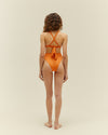 A back view of a model wearing matching two piece orange swim suit. The top features crisscross straps that ties back. The bottoms have a high-waisted cheeky design.