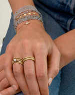 Models wrist wearing bracelet with other styles to show versatility. 