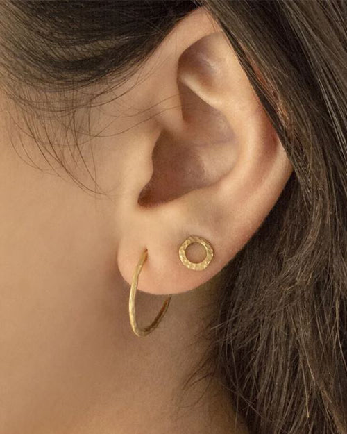 Model's ear wearing Open Hammered Circle Stud Earring.