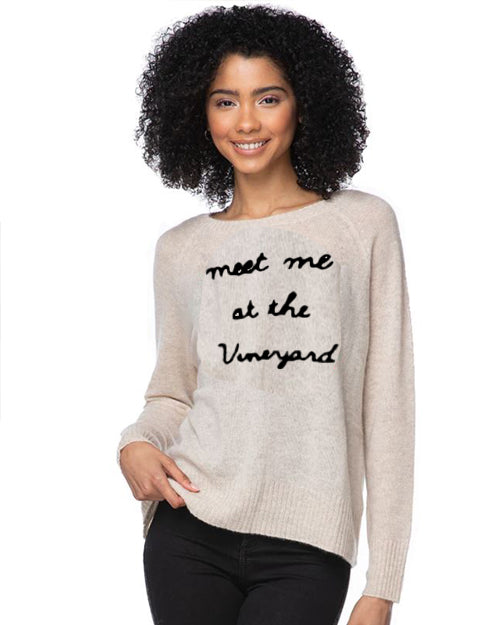 Model wearing Meet Me At The Vineyard sweater on a white background.