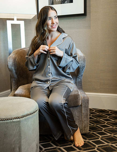 Model wearing pajama set seating on a sofa chair.