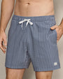 Navy and white gingham swim trunks featuring a classic check pattern, elastic waistband, white drawstring closure, and side pockets.