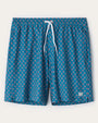Blue geometric print swim trunks with a red and white diamond pattern, elastic waistband, white drawstring closure, and relaxed fit displayed on a light gray background.