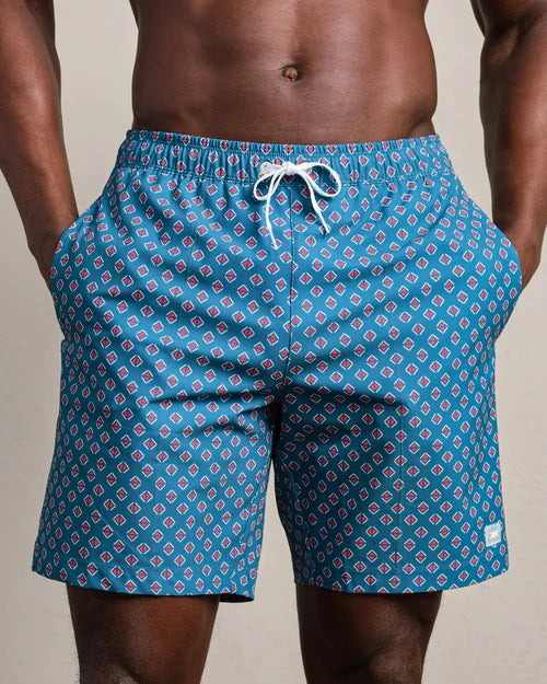 Blue patterned swim trunks featuring a geometric diamond print, elastic waistband with drawstring closure, and side pockets.