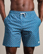 Blue patterned swim trunks featuring a geometric diamond print, elastic waistband with drawstring closure, and side pockets.