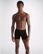 Image of a man standing wearing black long leg men's trunks.