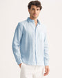 Model wearing a light blue and white striped pure linen long sleeve shirt.