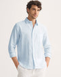 Model wearing a light blue and white striped pure linen long sleeve shirt.